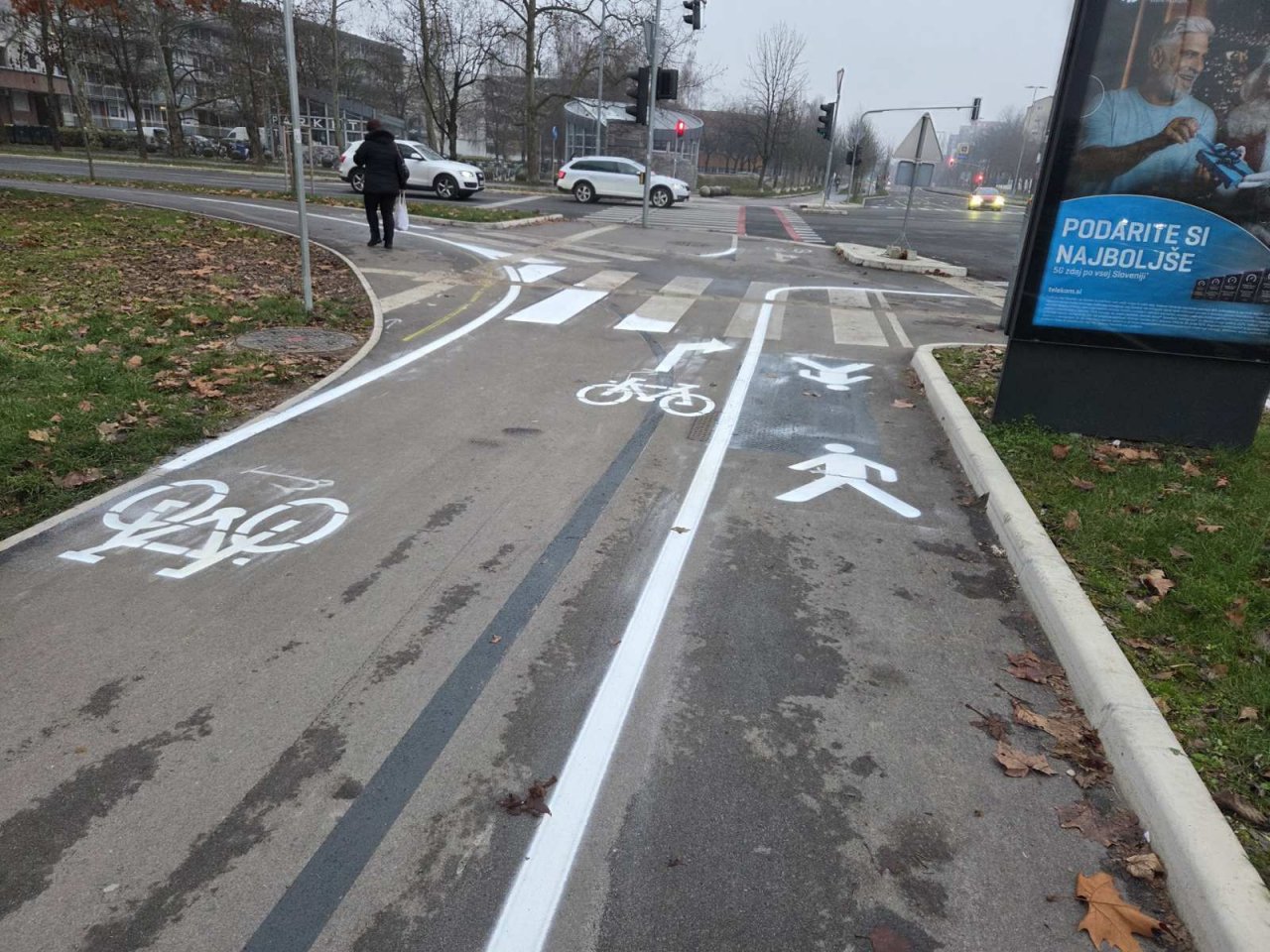Sicer logično, ampak zelo čudaško... Kolesarji lahko gredo le desno, pešci pa tudi, razen če gredo levo in ne gredo naravnost. Še kot otroci smo s kredo ali siporexom risali boljše ceste na naših dvoriščih. Teta na sliki je v "no man's land"